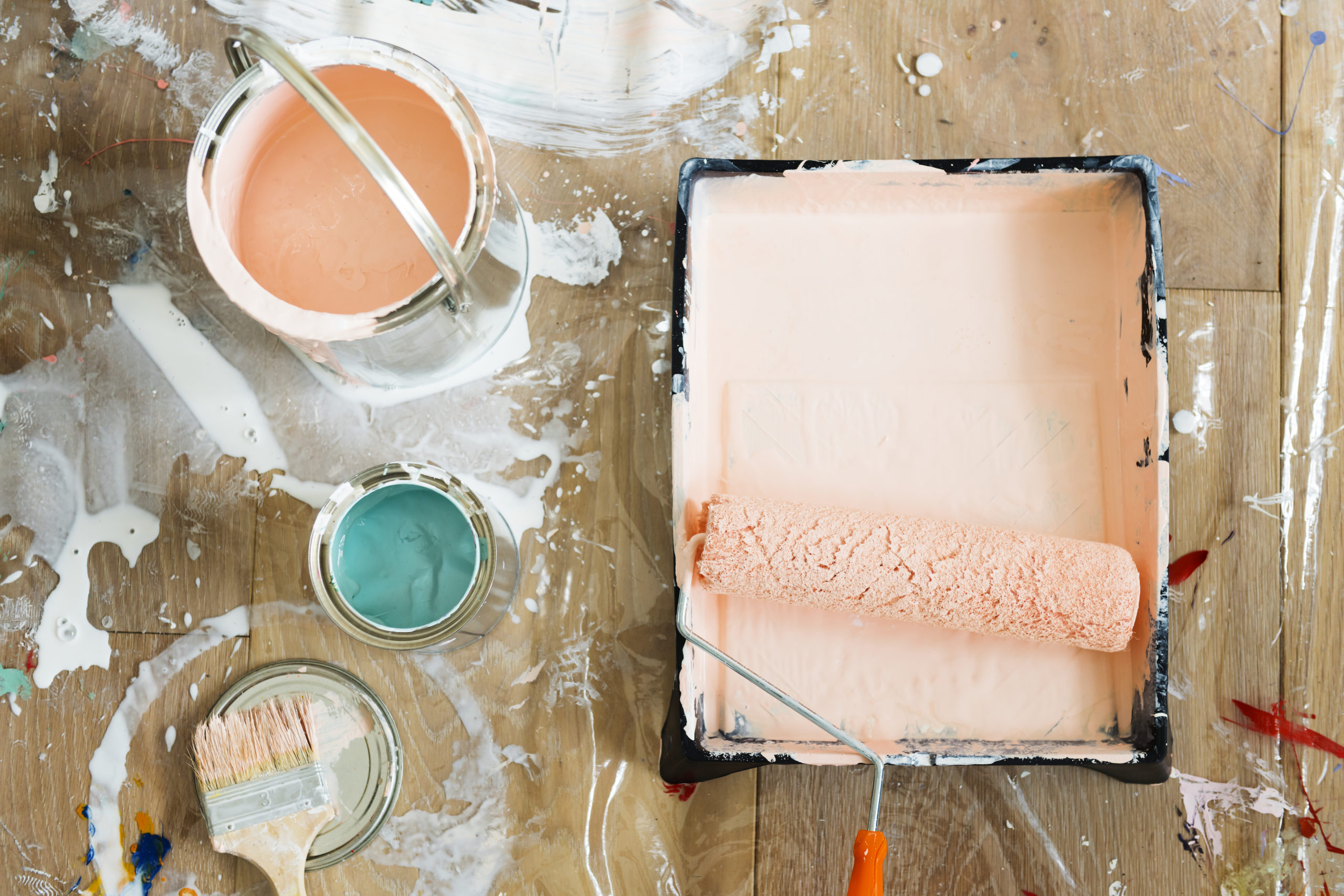 Paint brushes and colors on wooden floor